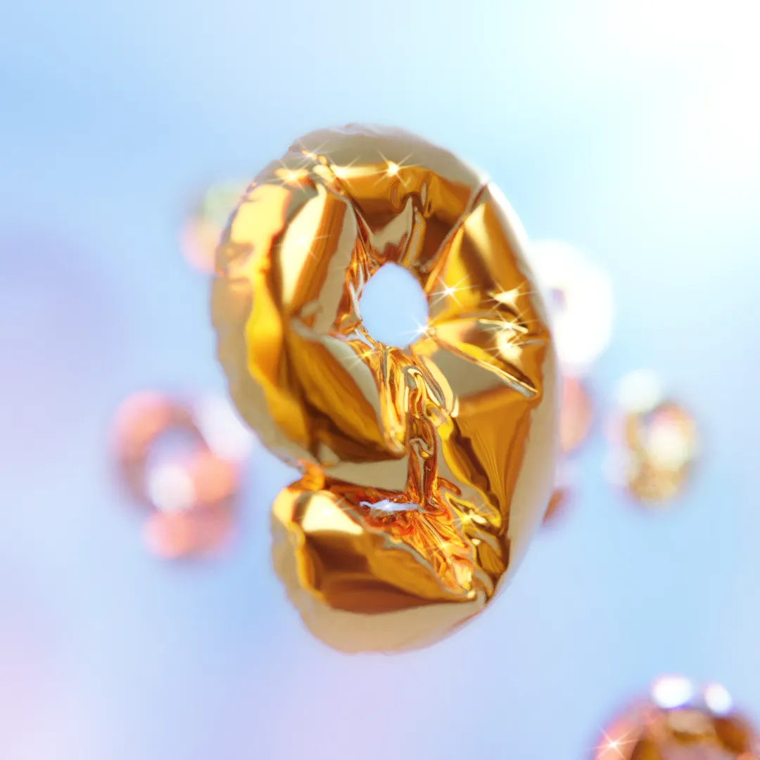 a 3d render of a gold foil balloon in the shape of the number nine, with other balloons in the background out of focus